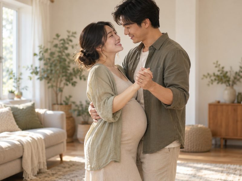 A woman who is 29 weeks pregnant slow-dancing with her partner in a sunlit living room